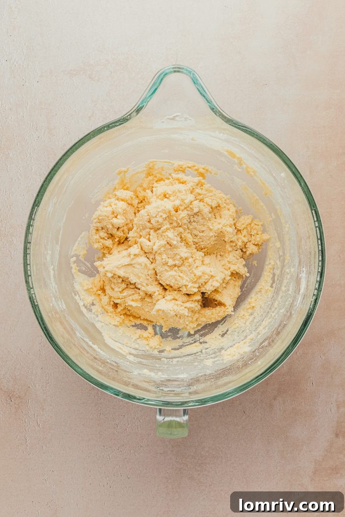 A glass bowl filled with soft lemon sugar cookie dough, perfectly mixed and ready for shaping.