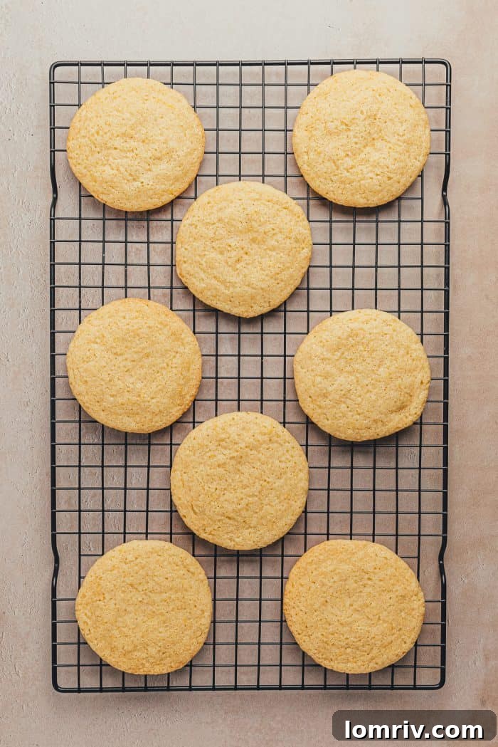 Freshly baked lemon sugar cookies arranged on a wire cooling rack to cool completely.