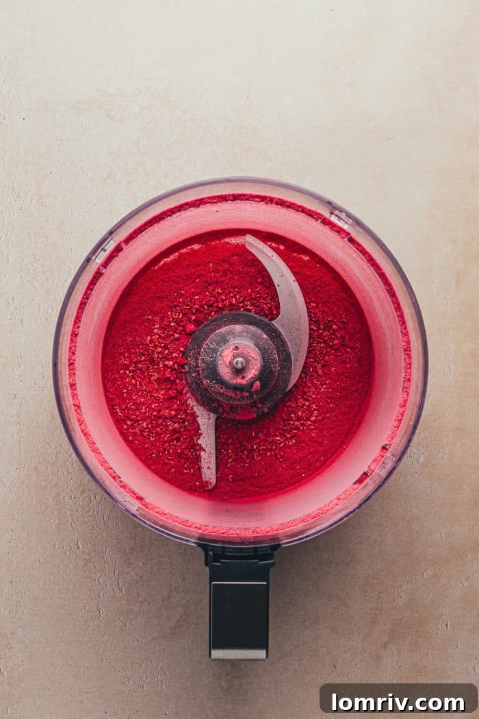 Freeze-dried raspberries in a food processor, ready to be blended into a fine powder.