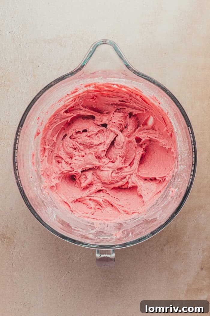 Cream cheese frosting tinted pink and flecked with raspberry bits, after being mixed with freeze-dried raspberries.