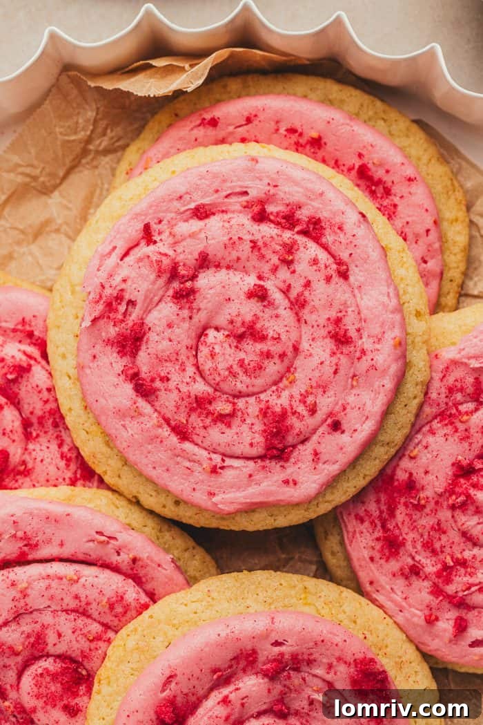 Stacked lemon sugar cookies with raspberry cream cheese frosting, showcasing their generous size and tempting appearance.