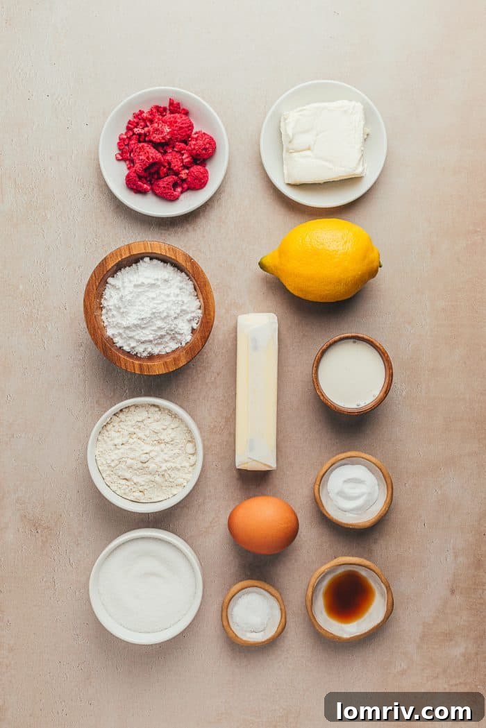 A collection of ingredients laid out for making lemon sugar cookies, including lemons, butter, sugar, flour, and freeze-dried raspberries.