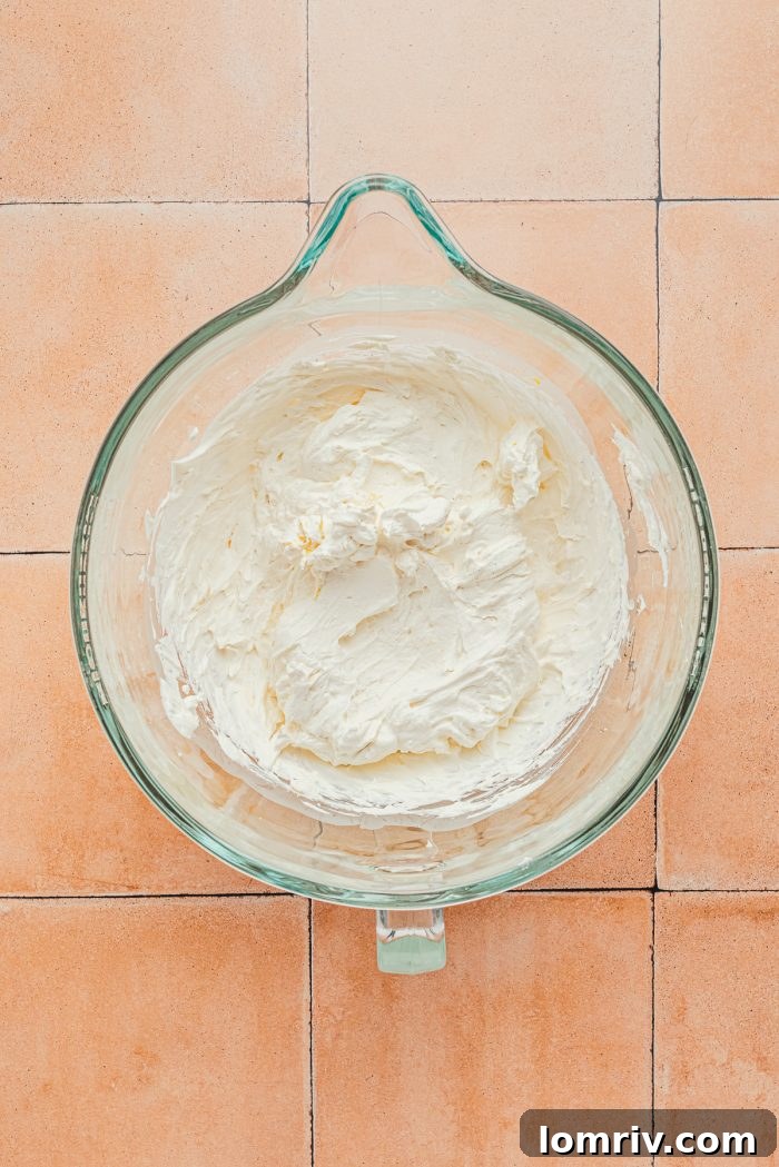 Whipped heavy cream and Mascarpone cheese in a glass bowl.