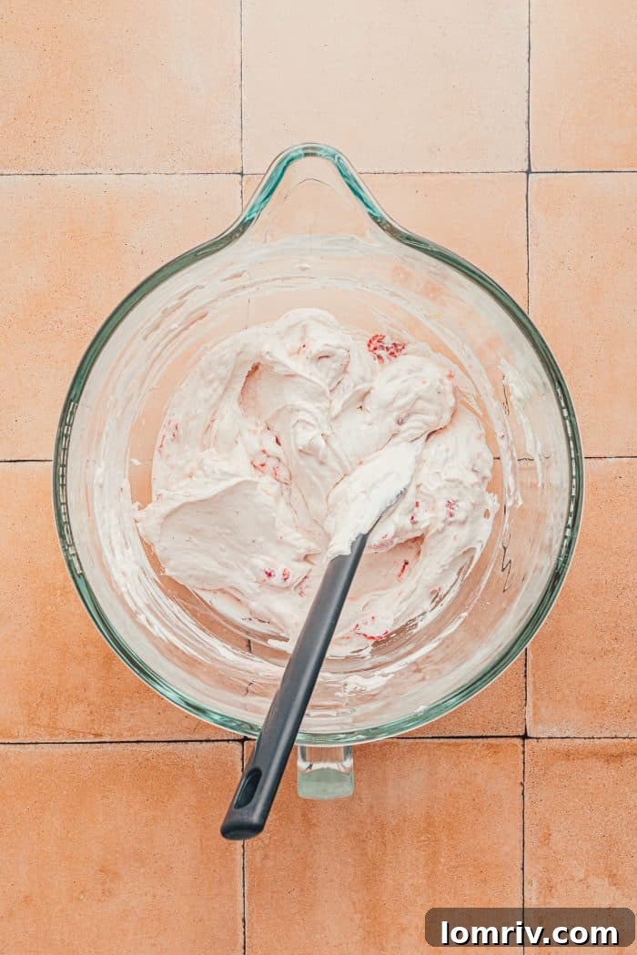 The heavy cream mixture mixed with the strawberry mixture in a glass bowl.