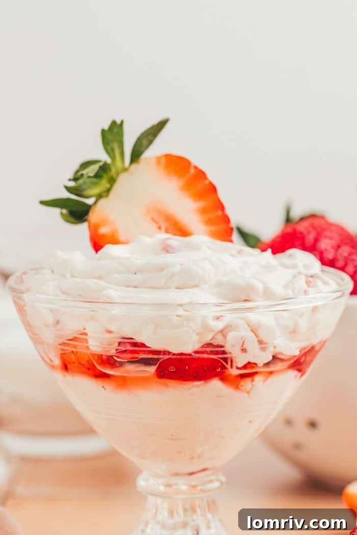 A glass parfait dish with strawberry mascarpone fool.