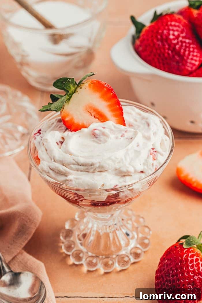 A glass parfait dish with homemade strawberry fool.