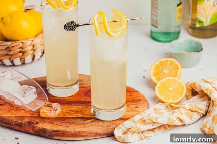 Two glasses of lemon elderflower mocktail, elegantly arranged on a wooden board, ready for a spring gathering.