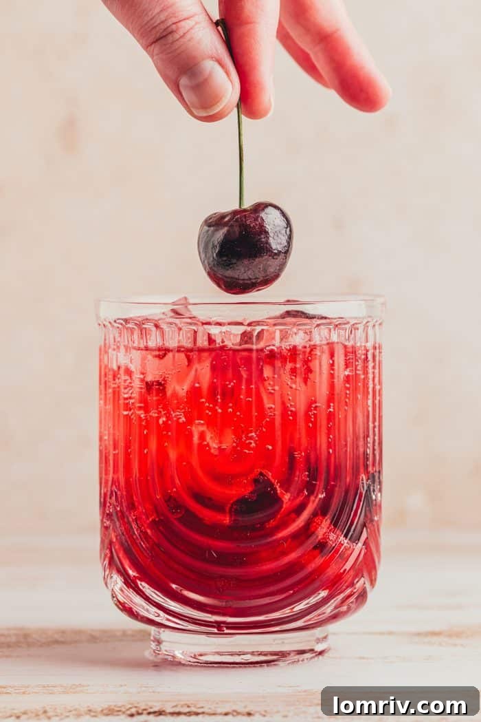 A virgin cherry Moscow mule being garnished with a cherry.