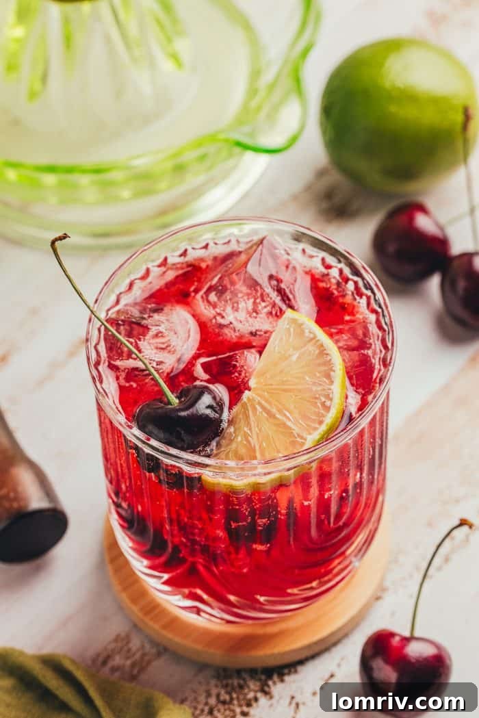 A virgin cherry Moscow mule garnished with lime slices and cherries.