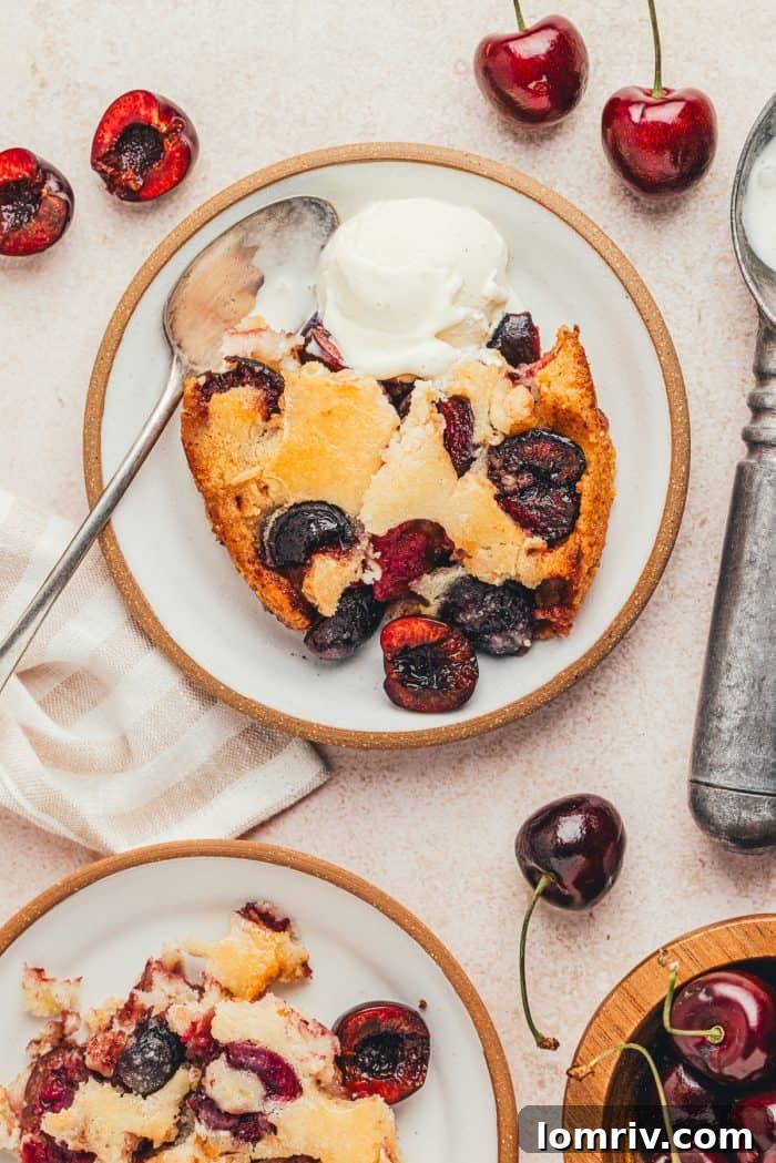 Two plates with scoops of browned butter cherry cobbler and vanilla ice cream.