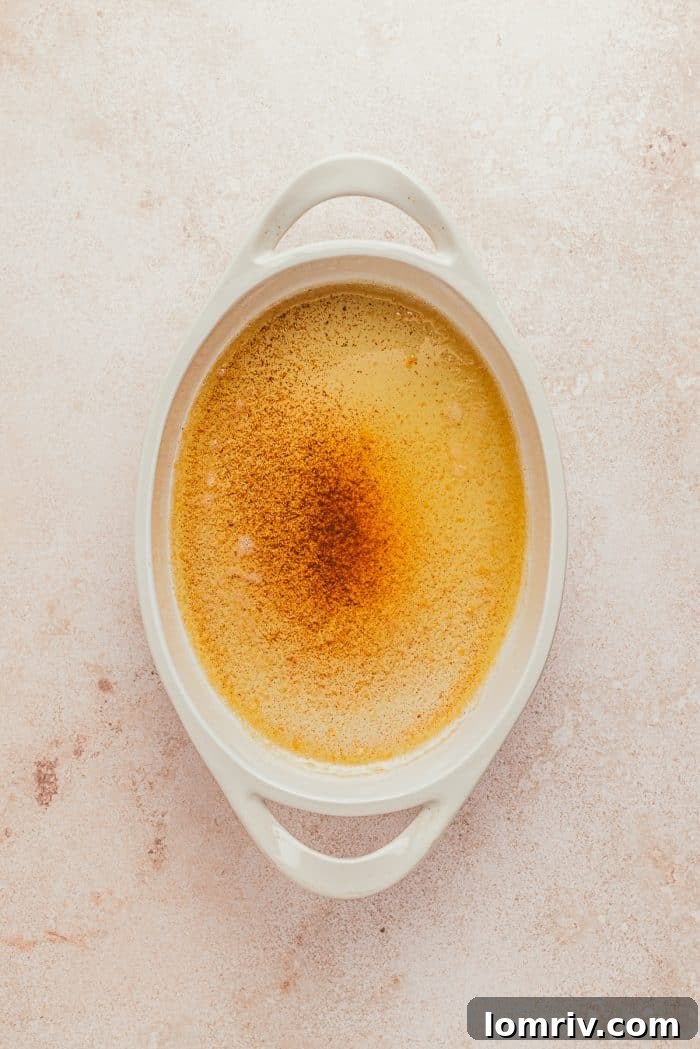 A white oval dish with melted brown butter in it.