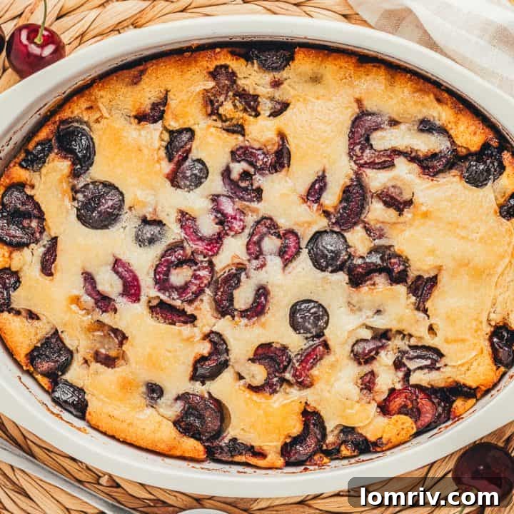 A white oval dish with baked cherry cobbler in it.
