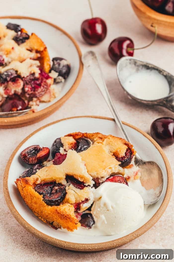 Two plates with scoops of browned butter cherry cobbler and vanilla ice cream.