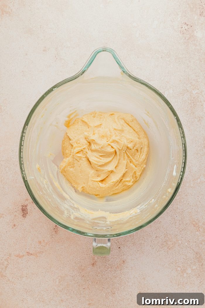 The thick, smooth cake batter mixture in a stand mixer bowl, ready for baking.