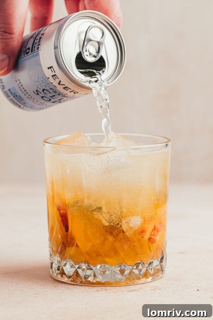 Topping the drink off with club soda.