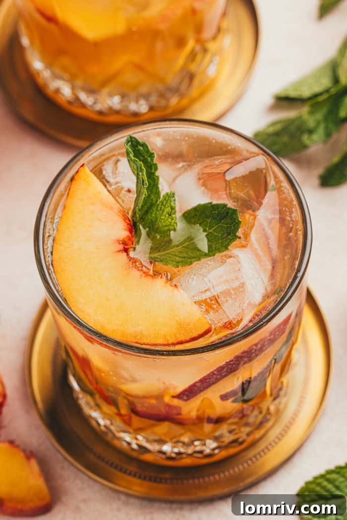An upclose of a peach bourbon smash.