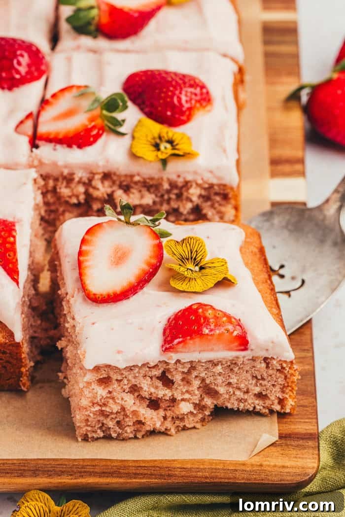 An array of delicious strawberry sheet cake slices, beautifully displayed on a wooden surface