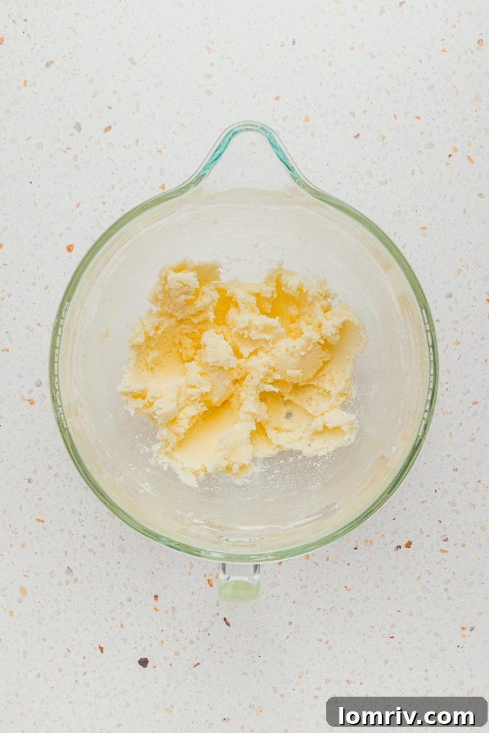 A glass mixing bowl containing softened butter, ready to be creamed with sugar for the cake batter