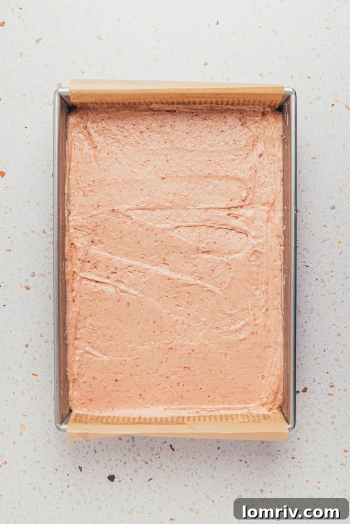 The unbaked strawberry sheet cake batter smoothly spread in a baking pan, ready for the oven