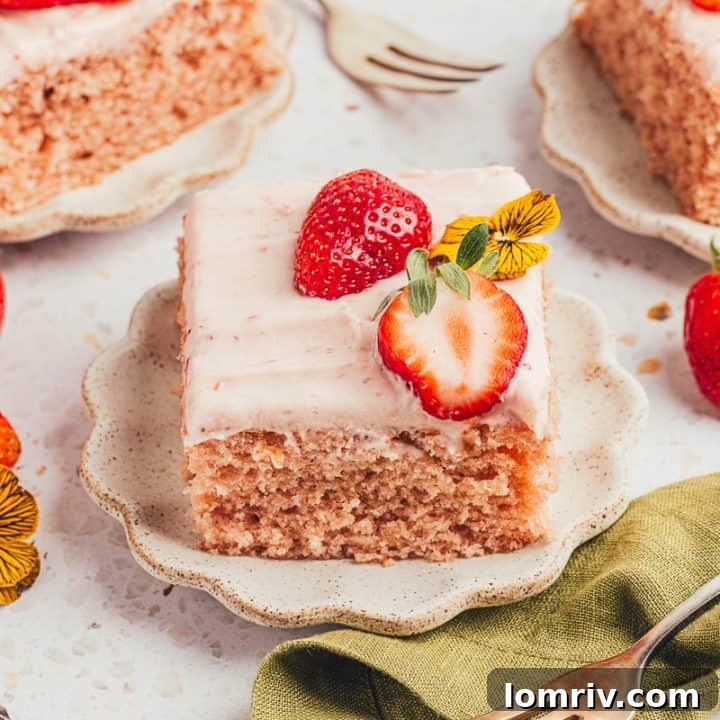 Three slices of strawberry sheet cake on plates with strawberries around them.