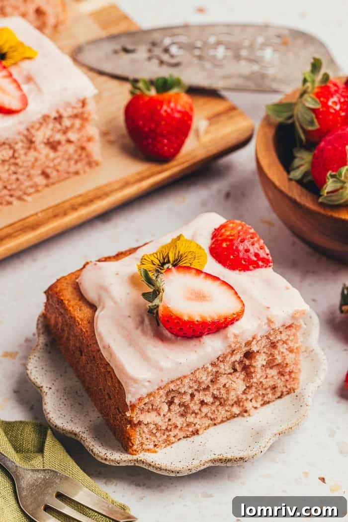 An inviting slice of strawberry sheet cake on a small plate, ready to be enjoyed