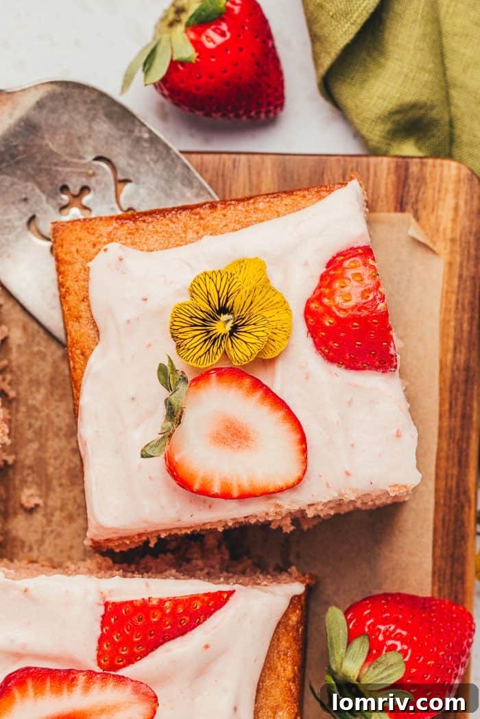 A close-up shot of a tender slice of strawberry sheet cake, highlighting its delightful texture