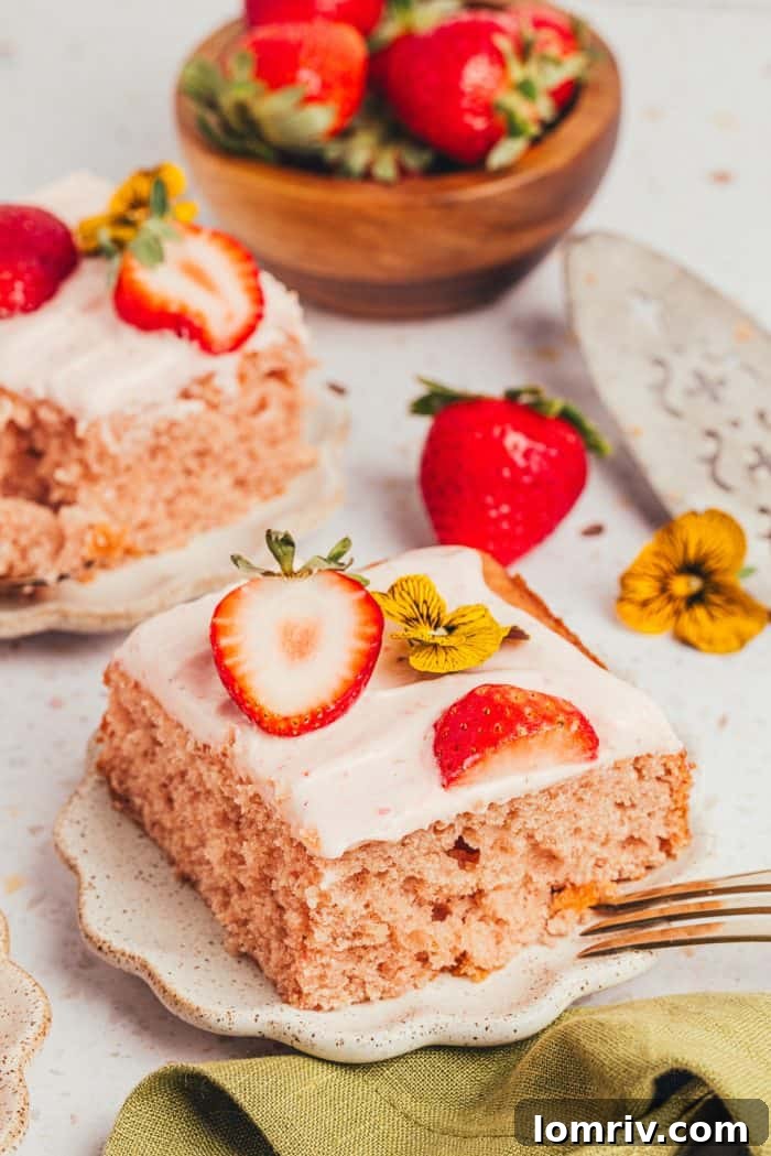 More tempting slices of strawberry sheet cake on plates, surrounded by fresh, juicy strawberries
