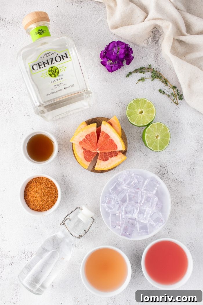 All the fresh ingredients meticulously laid out for preparing a delicious Guava Paloma cocktail.
