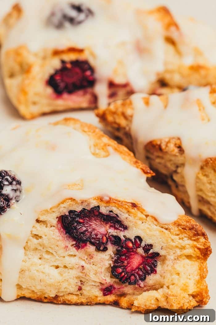 Freshly baked blackberry scones generously drizzled with a bright lemon glaze.