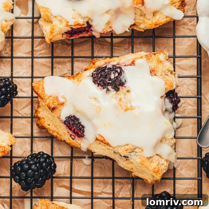 Glazed blackberry scones on a cooling rack.