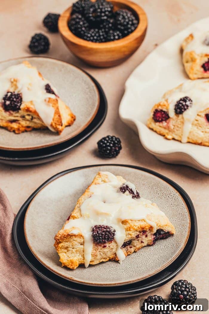 A plate featuring a perfectly glazed blackberry scone ready to be enjoyed.
