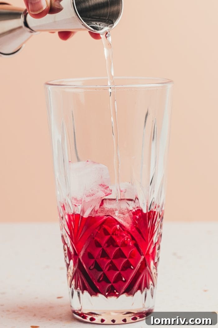 A glass bottle filled with rich purple homemade blueberry simple syrup, ready for use.