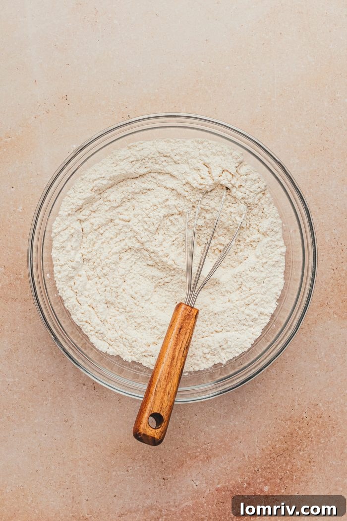 The dry ingredients in a glass bowl with a whisk.