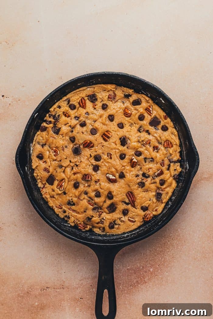 Raw chocolate chip cookie dough added to a greased skillet.