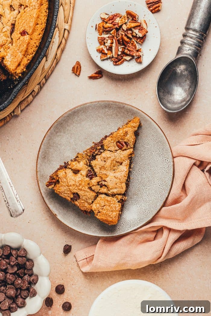 A plate with a slice of brown butter pecan chocolate chip skillet cookie.