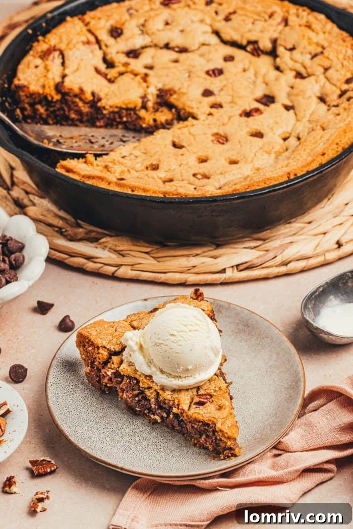 A plate with a slice of brown butter pecan chocolate chip skillet cookie.