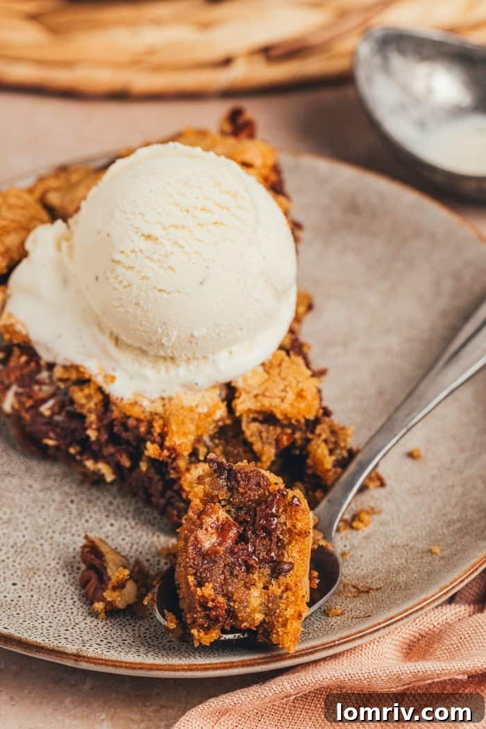 A plate with a slice of brown butter pecan chocolate chip skillet cookie.