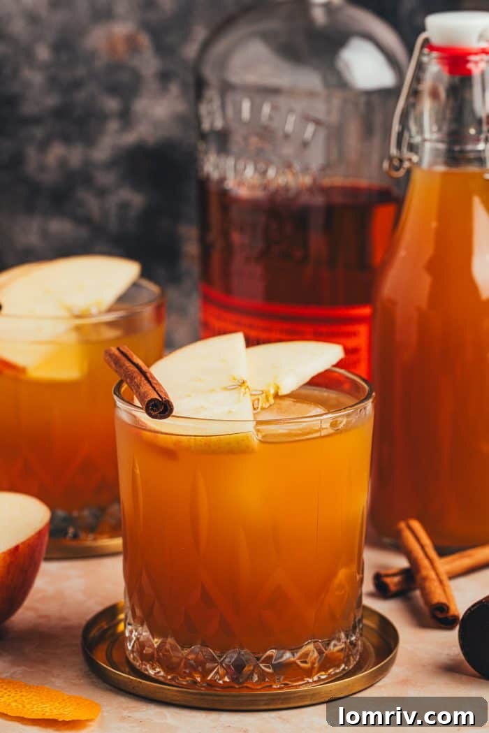 Another view of the Apple Cider Old Fashioned, highlighting its inviting color and the freshness of the apple slices.