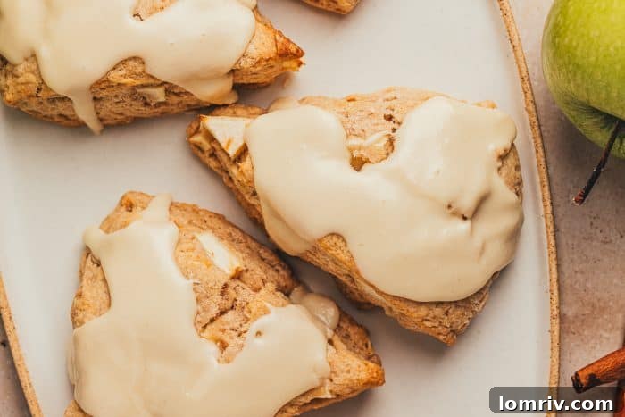 Three apple & cinnamon scones on a plate.