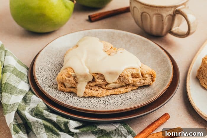 A cinnamon apple scone on a plate with a plaid green towel.