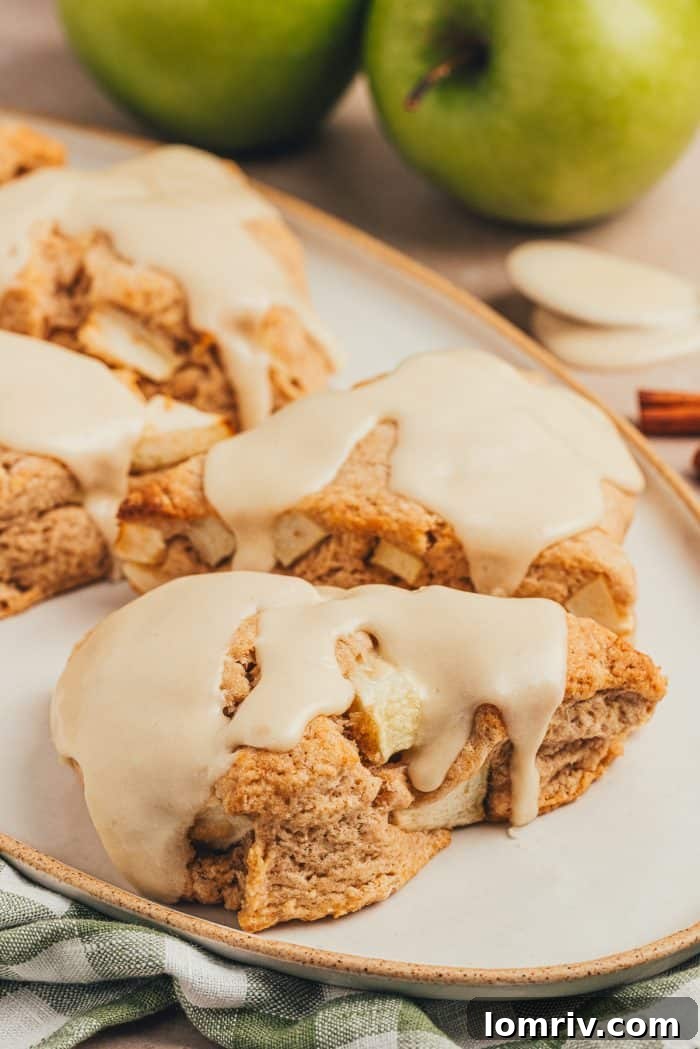 Four apple & cinnamon scones on a plate.