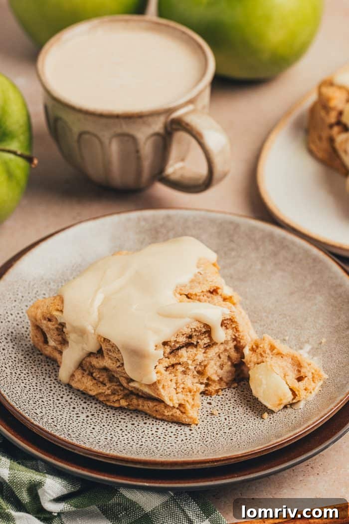 A cinnamon apple scone on a plate with a plaid green towel.