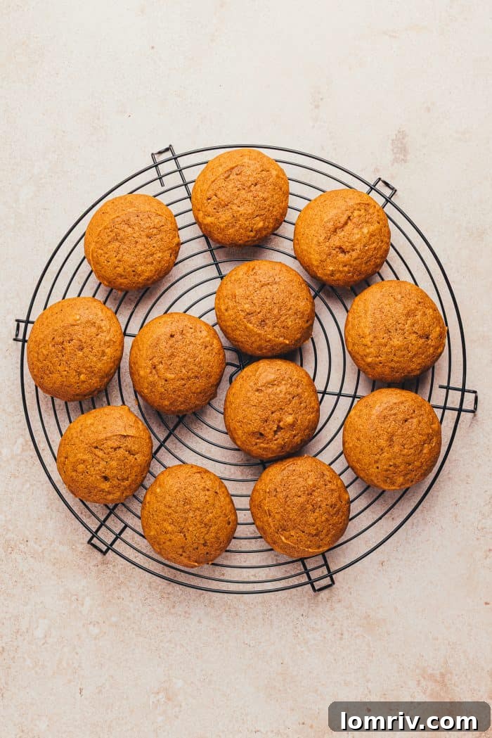 Perfectly baked pumpkin whoopie pies resting on a wire cooling rack, ready for their delicious filling.