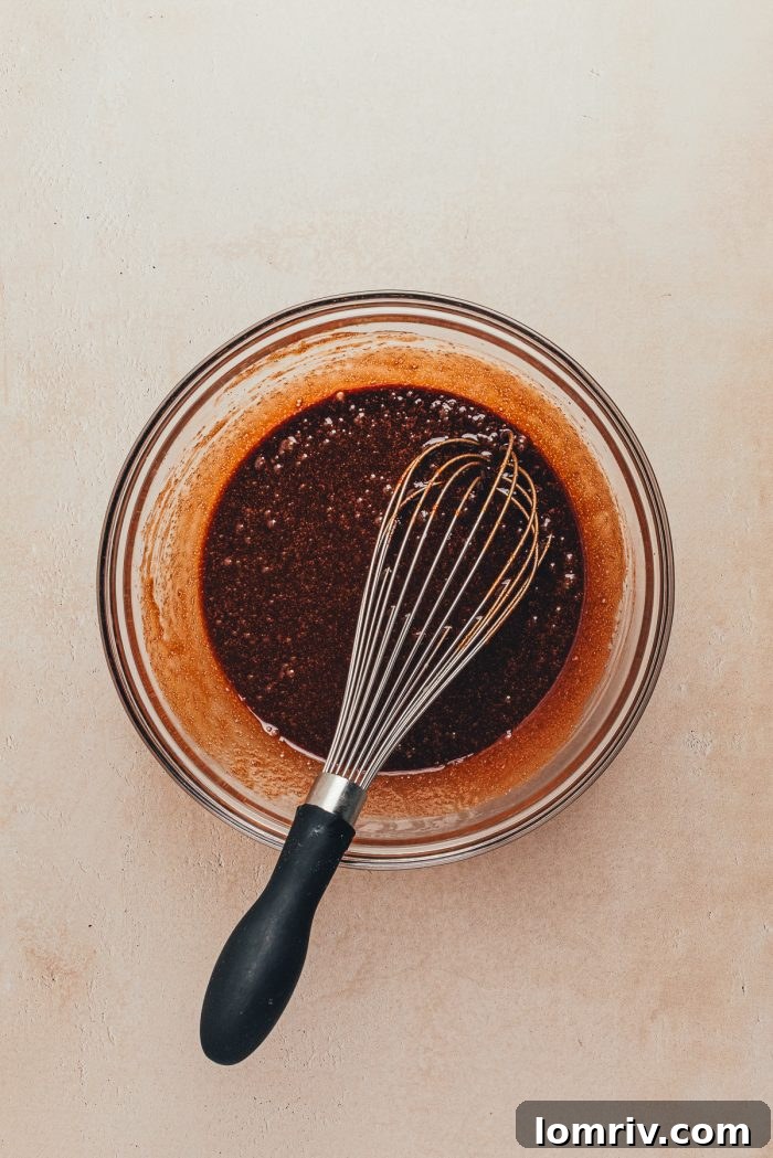 The melted butter and chocolate in a glass mixing bowl.