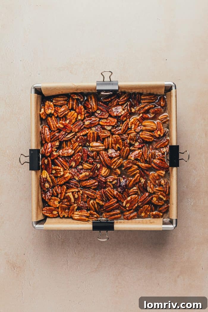 The pecan mixture poured over the baked brownies.