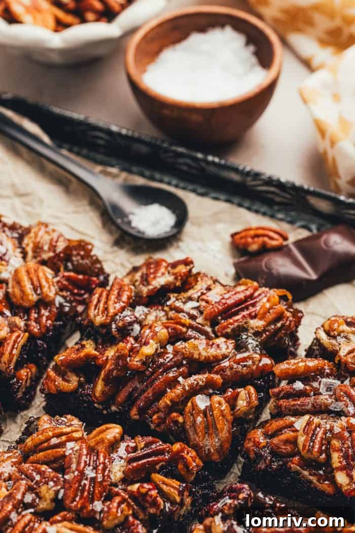 A few pecan pie brownies are sliced on a baking sheet with parchment paper.