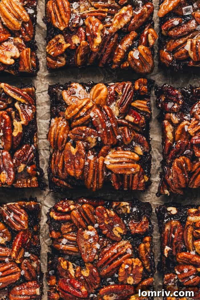 Pecan Pie Brownies are sliced and displayed on parchment paper.