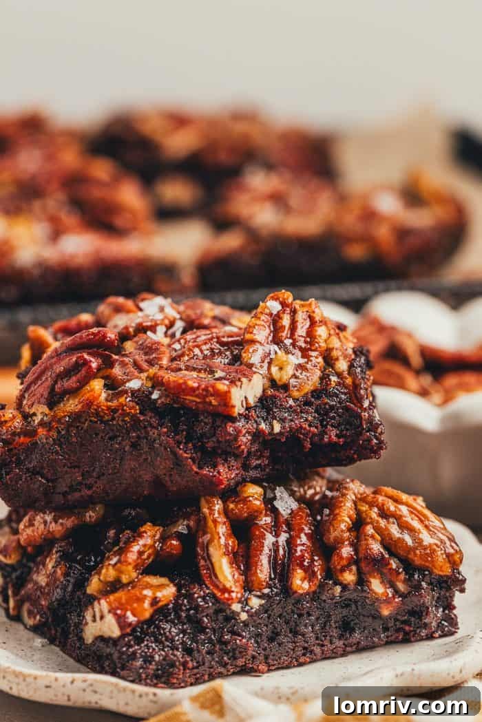 Two pecan pie brownies are on a white plate.