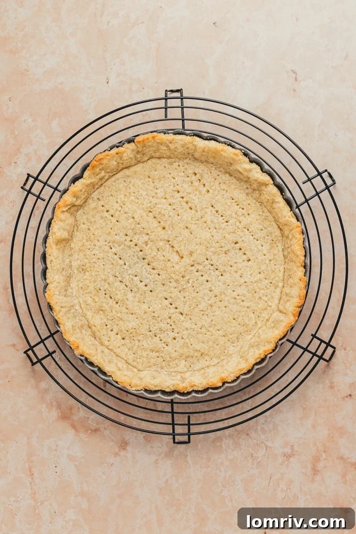 A beautifully blind-baked tart shell, golden and perfectly formed, cooling on a wire rack.