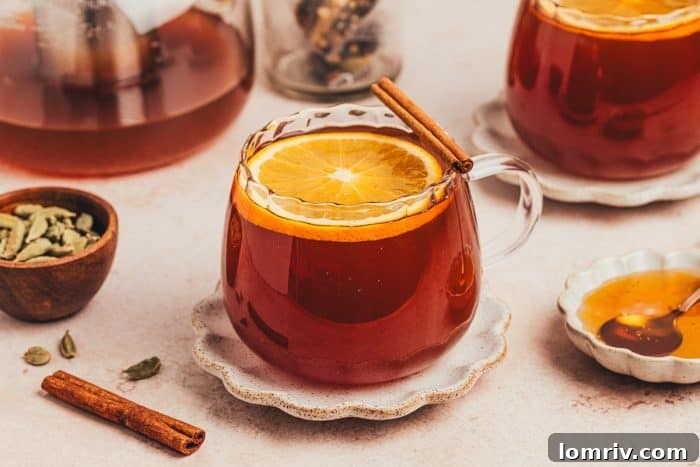 A solitary glass of chai vanilla bean hot toddy, beautifully presented with cinnamon sticks nearby, exuding warmth.